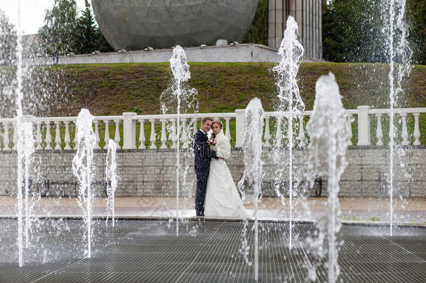新郎和新娘挨着喷泉和喷水池