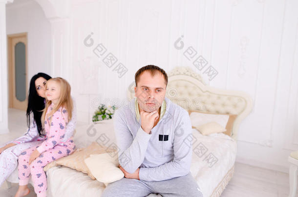 夫妻<strong>争吵</strong>和孩子心烦意乱，坐在白色的室内床上