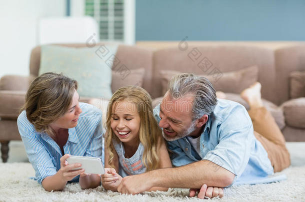 一家人在客厅里一起躺在地毯上，从手机上自拍