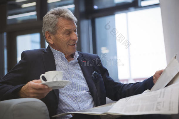 商人一边喝咖啡一边看报纸