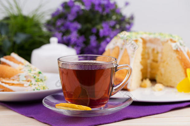 紫色桌布上瓷餐具上的一杯茶和蛋糕