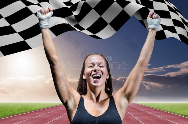 运动员在赛道上用格子旗庆祝她的胜利