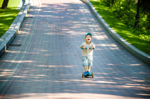 男孩在当地公园玩滑板车
