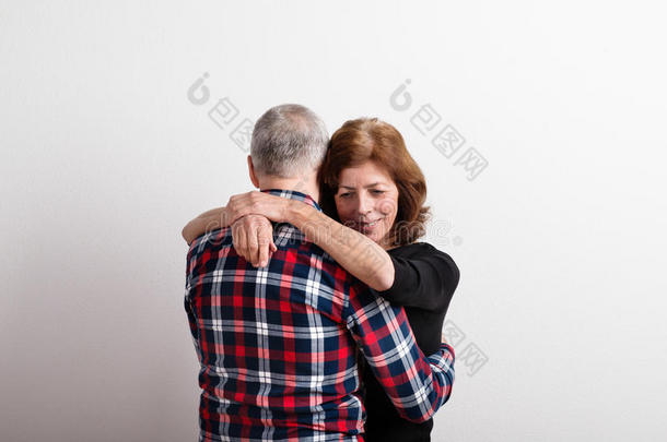 美丽的老年夫妇相爱拥抱。 摄影棚拍摄。