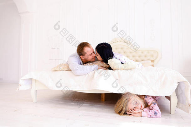 女儿躲在床底下，爸爸妈妈亲吻寻找孩子