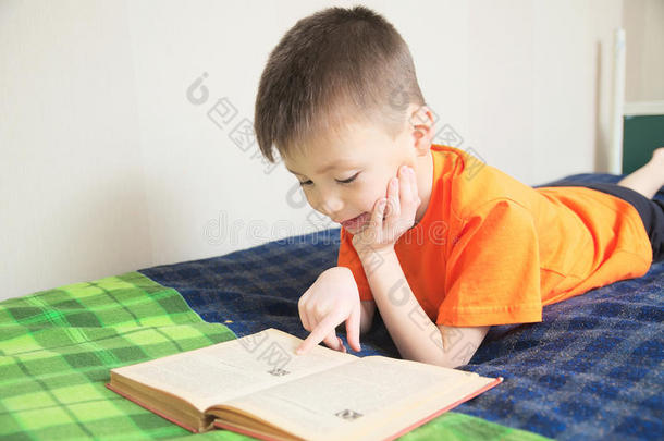 <strong>孩子</strong>教育，男孩<strong>看书</strong>躺在床上，<strong>孩子</strong>肖像微笑着带着书，有趣的故事书