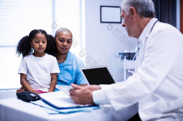 医生使用数字平板电脑，同时与病人互动