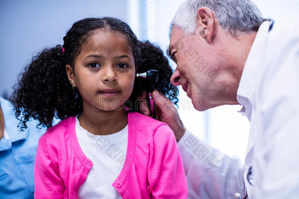 医生用耳镜检查病人的耳朵