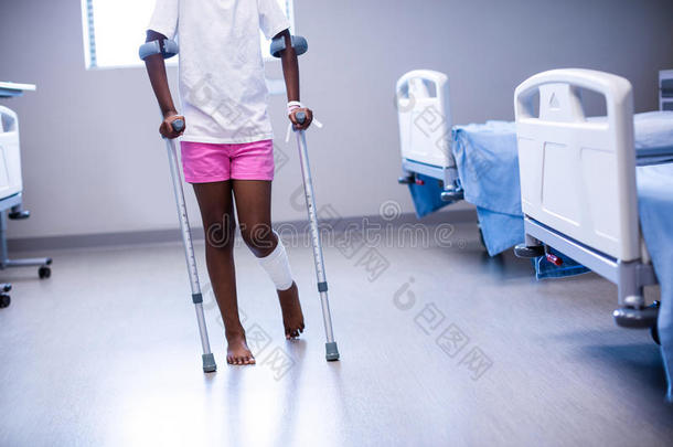 在病房里拄着拐杖走路的女孩