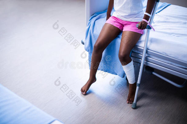 坐在病房病床上的拐杖女孩