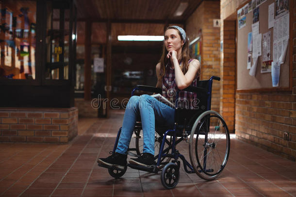 在学校走廊上坐轮椅的残疾女学生