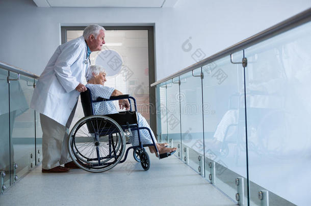 轮椅上的医生和高级病人在通道里
