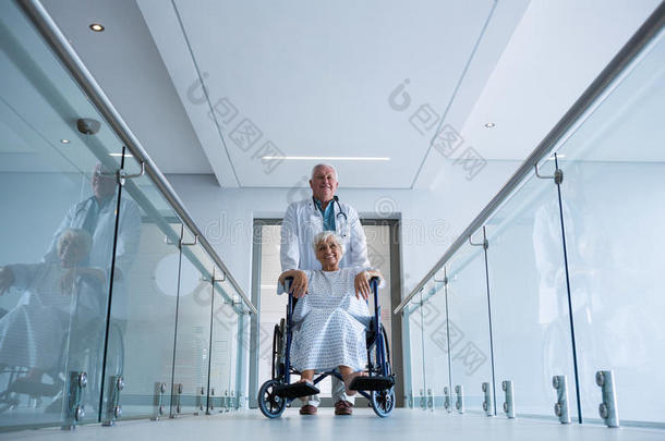 医生在通道上把<strong>老年</strong>病人扶在<strong>轮椅</strong>上