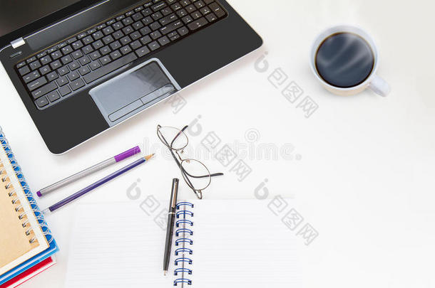 笔记本电脑，眼镜，钢笔，铅笔，热咖啡杯在白色桌子上