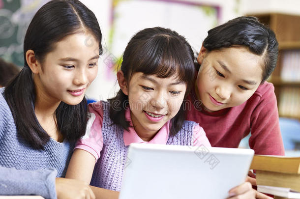 亚洲小学生在教室里使用平板电脑