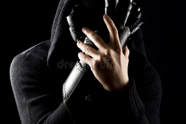 情感，年轻和有吸引力的刺客在手套上的黑色背景。
