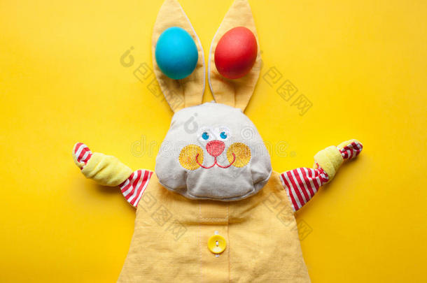 复活节装饰从一个手工玩具兔子和彩色鸡蛋在橙色的背景