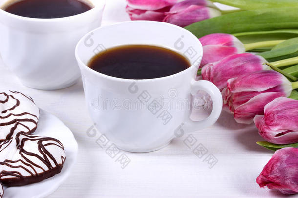早餐包括咖啡、新鲜郁金香和木桌上的蛋糕。