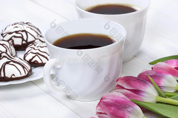 早餐包括咖啡、新鲜郁金香和木桌上的蛋糕。