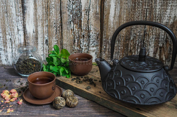 一个<strong>黑</strong>茶壶，绿茶和一杯茶旁边的薄荷