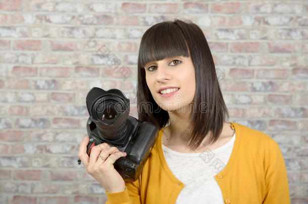 漂亮的黑发女人带着照片相机