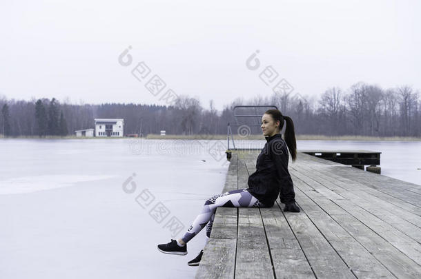 美丽的瑞典白种人健身少女坐在木桥上