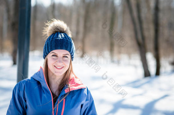 穿着运动服的漂亮女孩在冬天的森林背景上