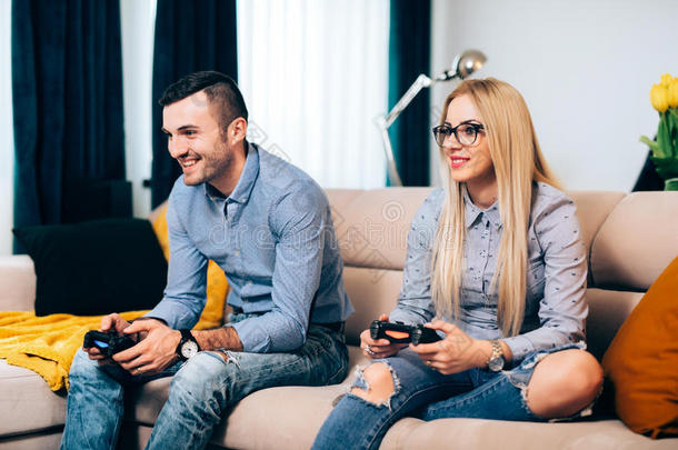 一对夫妇在控制台上玩电脑游戏和电子游戏，而电子游戏