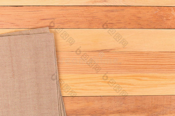 木桌上的布料。 软棕色编织亚麻织物纹理