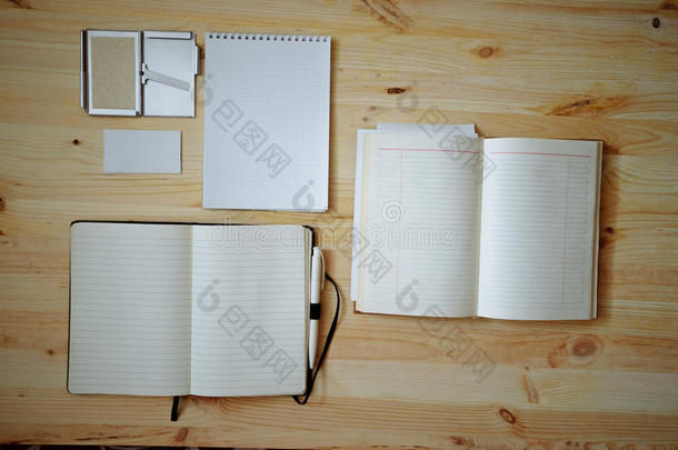 旧木背景上的空白文具：名片、小册子、笔记本、记事本和钢笔。 复古风格