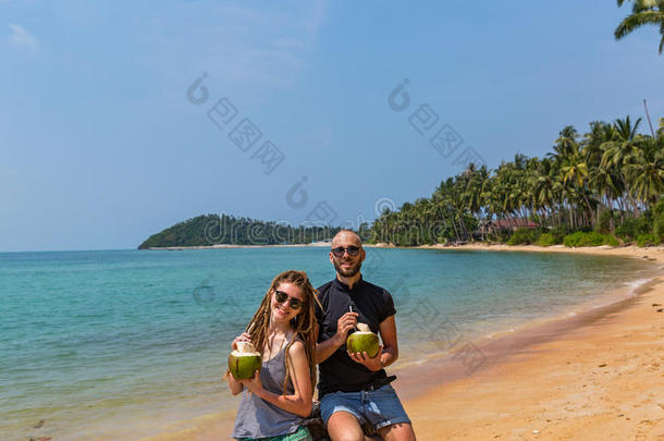 一对夫妇在海滩上喝<strong>椰子汁</strong>
