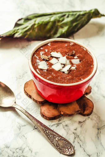 巧克力布丁在一个红色的碗，椰子，浆果和辣椒图片