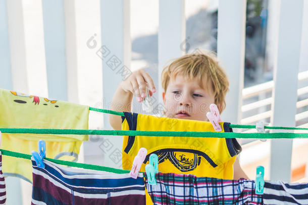 一个小男孩帮她妈妈挂衣服