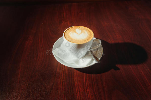 用拿铁艺术放在木桌上的一杯咖啡。 街头咖啡。 上面的风景。