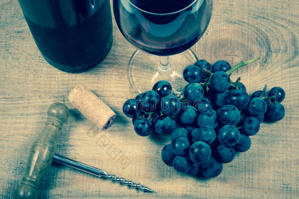 一杯红酒，木桌上有一串葡萄。