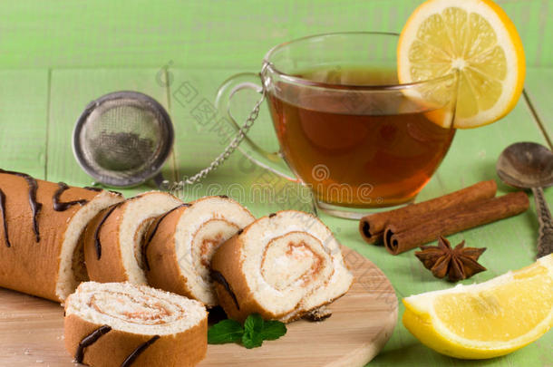 饼干瑞士卷与一杯茶在绿色木制背景