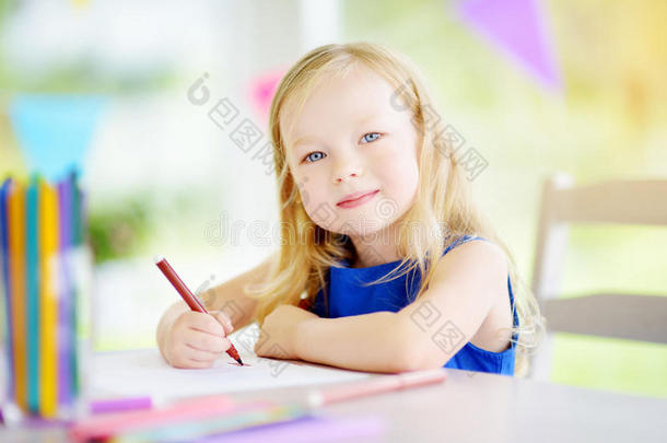 可爱的小女孩在托儿所用<strong>彩色铅笔画</strong>画。 学校里有创意的孩子绘画