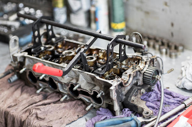 汽车修理工在车库用旧汽车发动机活塞和阀门