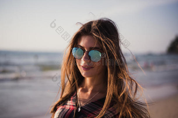 特写海滩上欢快的金发嬉皮士的肖像。 夏天海滩上的狂野女孩带着太阳镜，时髦的女孩风格