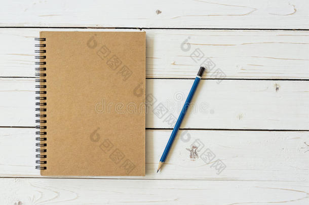 木制桌子上有铅笔的空白老式纸笔记本