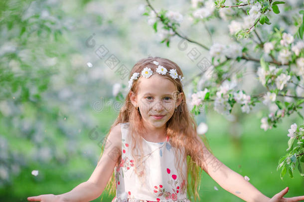 春日盛开的苹果树花园里可爱的小女孩
