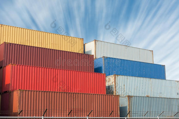 五颜六色的集装箱堆叠在蓝天背景上，重工业。