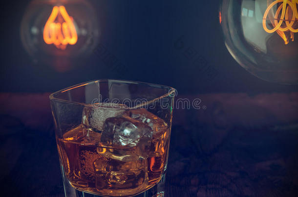 一杯威士忌，木桌上放冰块，温暖的气氛，用威士忌和一些小灯泡放松的时间