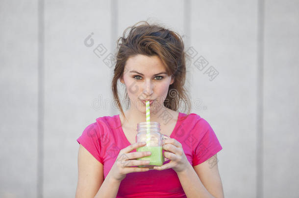 开朗的年轻健康的青少年妇女喝绿色营养j