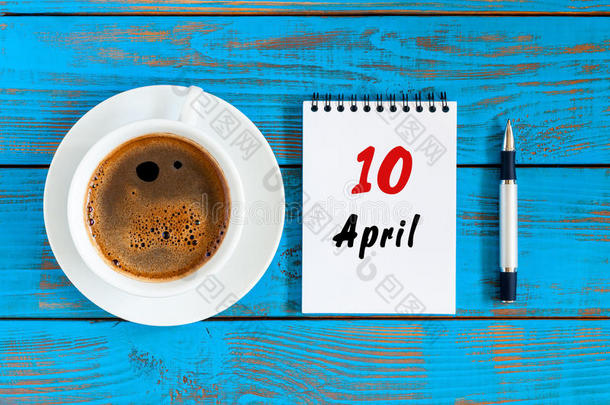 四月十日。 每月10日，活页日历与早晨咖啡杯，在工作场所。 春天的时候，顶景