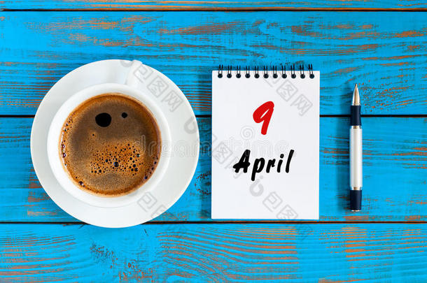 四月<strong>九日</strong>。每月的第9天，工作场所的活页日历和早晨的咖啡杯。春季，俯视图