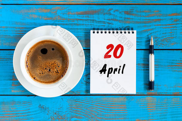 四月二十日。 每月20日，活页日历与早咖啡杯，在工作场所。 春天的时候，顶景