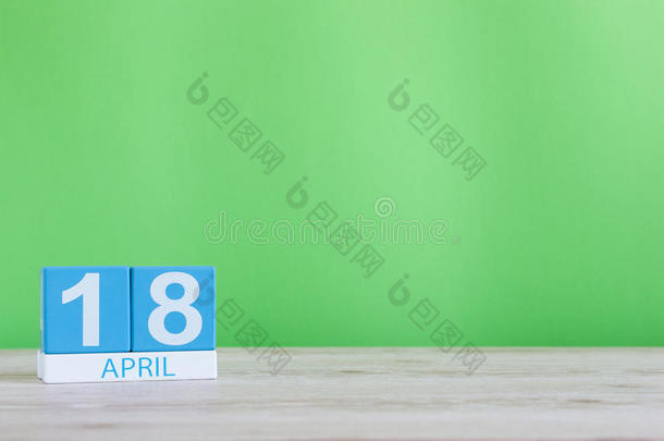 <strong>四月</strong>十八日。 月18日，木桌上的日历和绿色背景。 春天的时间，文字的空空间