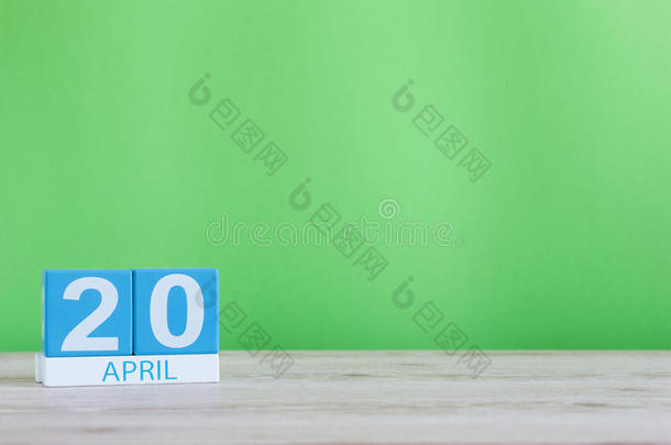 四月二十日。 每月20日，木桌上的日历和绿色背景。 春天的时间，文字的空空间