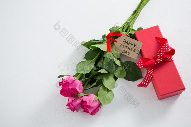 礼品盒和一束粉红色玫瑰，上面有快乐的母亲节标签
